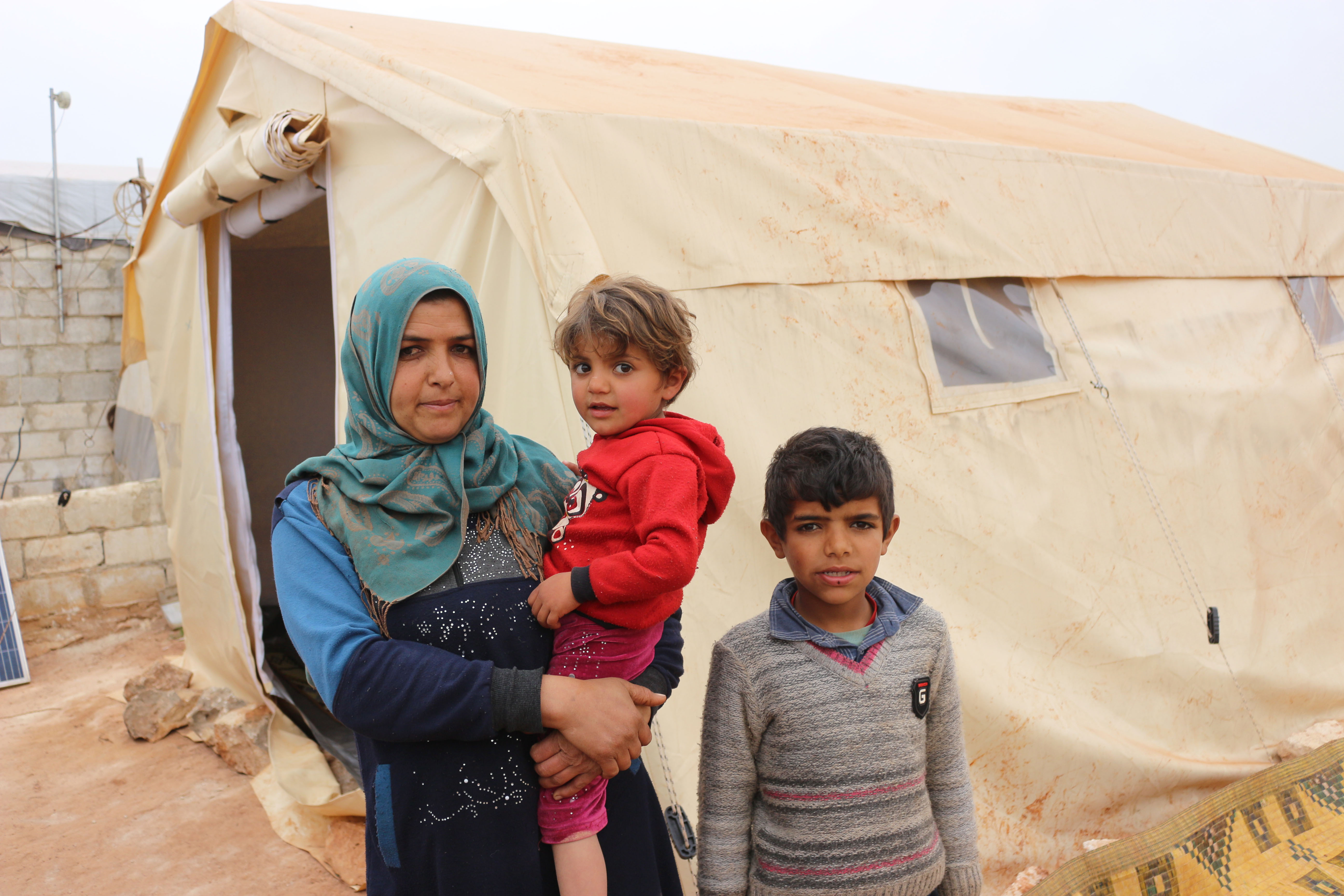Syrian family outside their tent