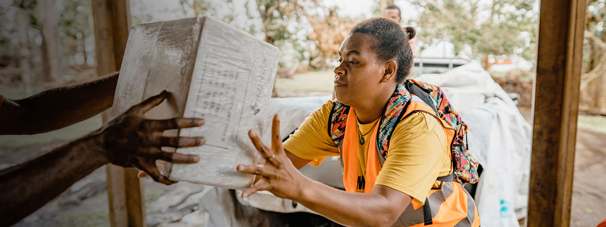 Woman passes aid box in Vanuatu