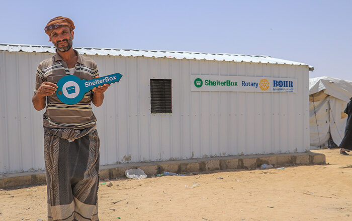Man standing outside iron net shelter
