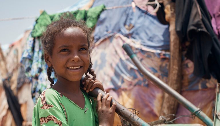 Little girl smiling outside a tent in Somaliland
